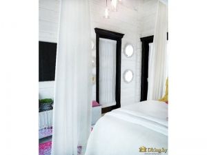 белая спальня. кровать занавешена белые легкими шторами. дверь темно-коричневого цвета со стеклом. стекло занавешено легкой органзой